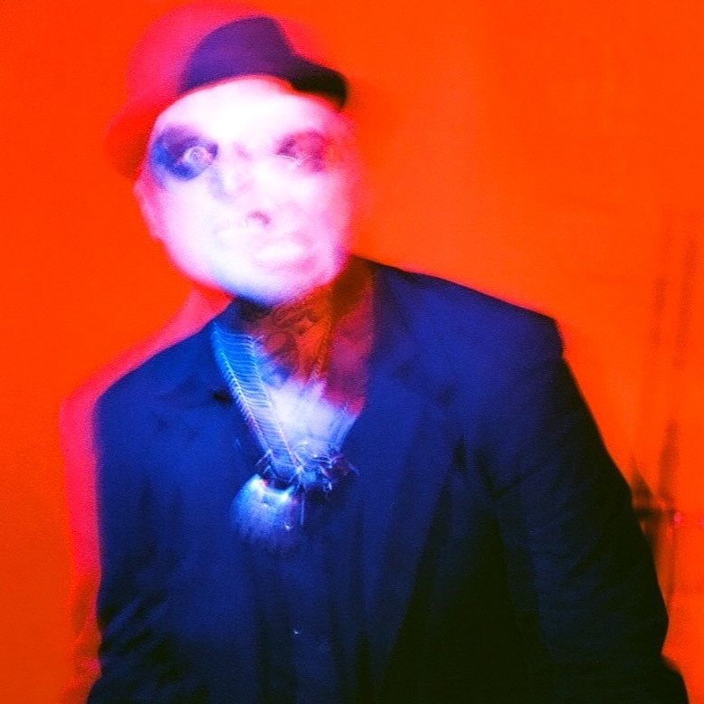 Paul Tergeist in a blurred portrait against a red background, on film